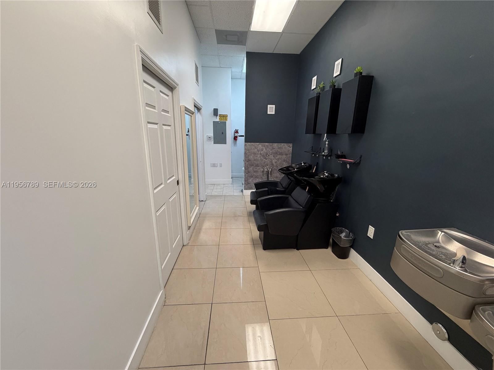 This salon area features two black shampoo stations against a dark blue accent wall — 18505 NW 75th Pl, Hialeah FL 33015, HIALEAH, FL