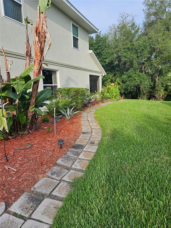 An entryway features a white front door, a staircase with dark carpet, and tile flooring — 5351 AURORA DRIVE, LEESBURG, FL