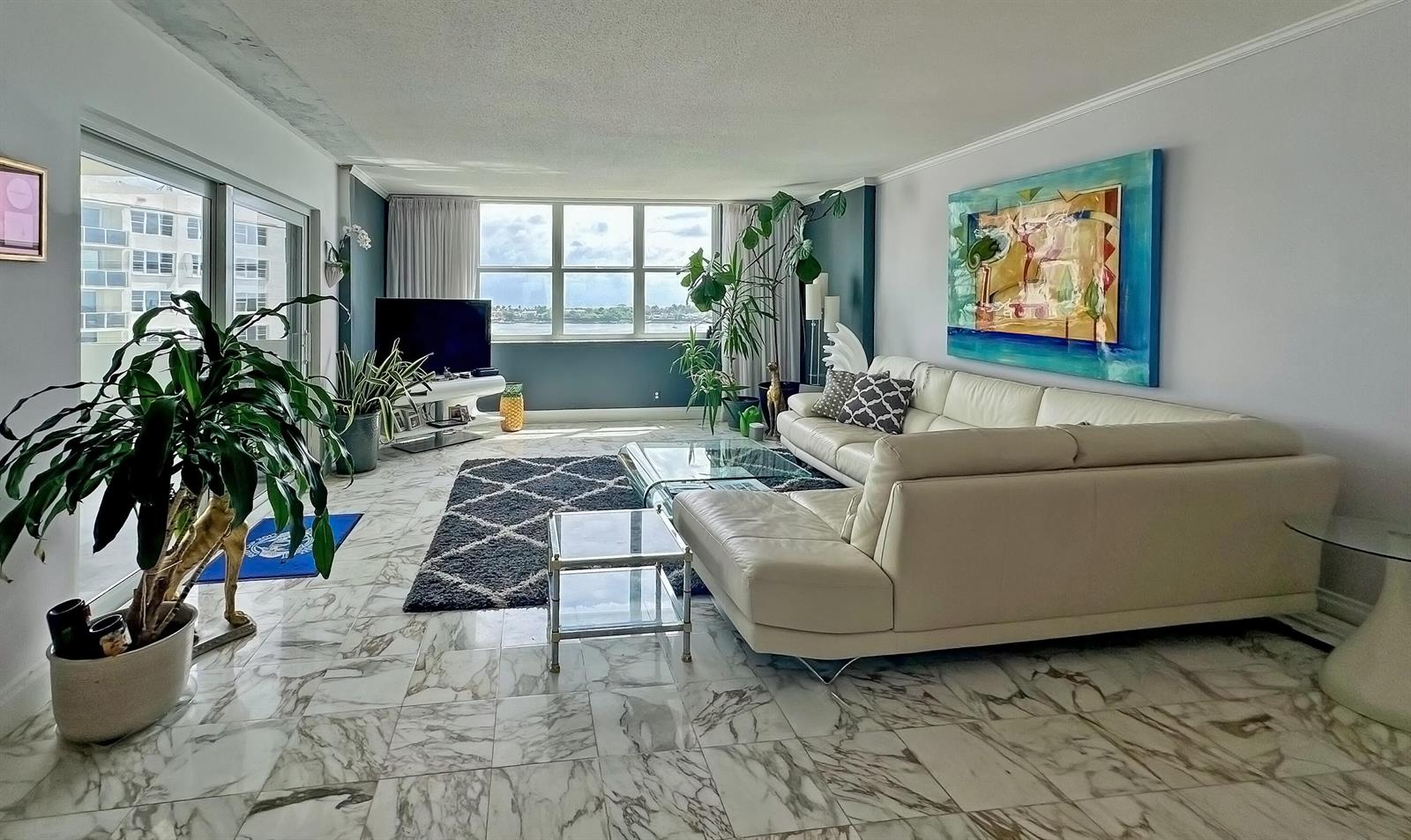 A living room features a white sectional sofa, marble flooring, and a large window view — 2600 N Flagler Drive # 803, West Palm Beach FL 33407, WEST PALM BEACH, FL