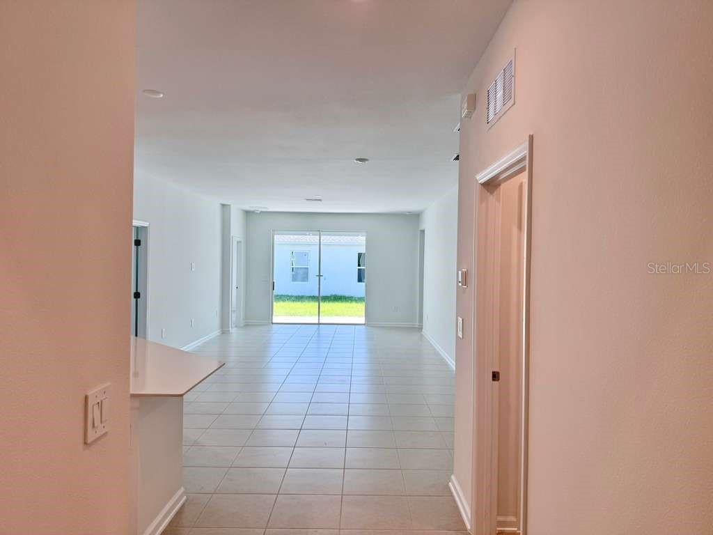 A view from a hallway looking into an open-concept living area with tiled floors — 3483 MUD CANYON DRIVE, DAVENPORT, FL