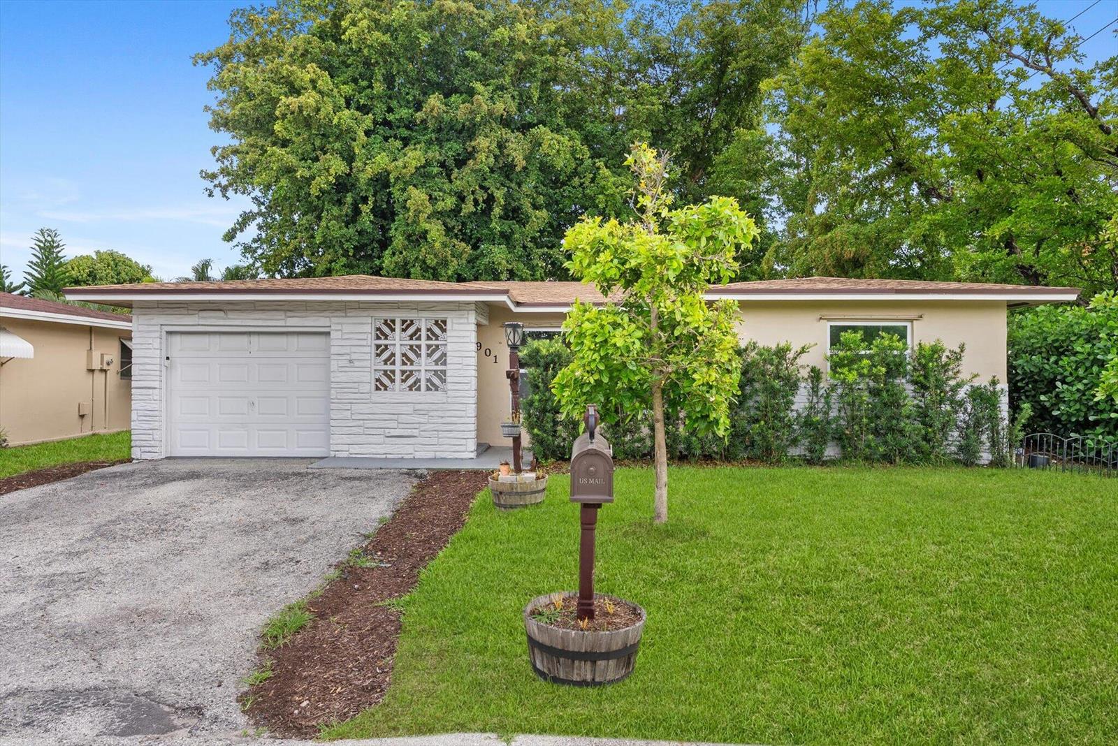 A single-story house with a white brick facade, a garage, and a front lawn — 901 NW 49th Street, Deerfield Beach FL 33064, DEERFIELD BEACH, FL