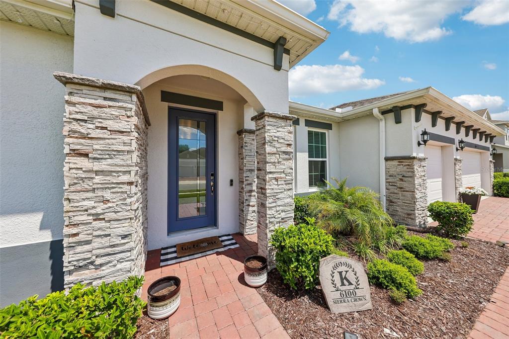 A front entrance features a blue door, stone columns, and a brick walkway — 6100 SIERRA CROWN STREET, MOUNT DORA, FL