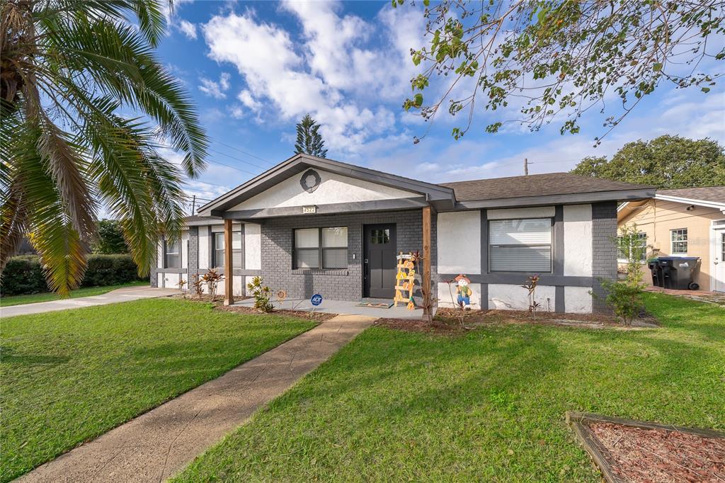 A single-story house with a gray brick and white stucco exterior, a palm tree, and walkway — 4522 FETROW DRIVE, ORLANDO, FL