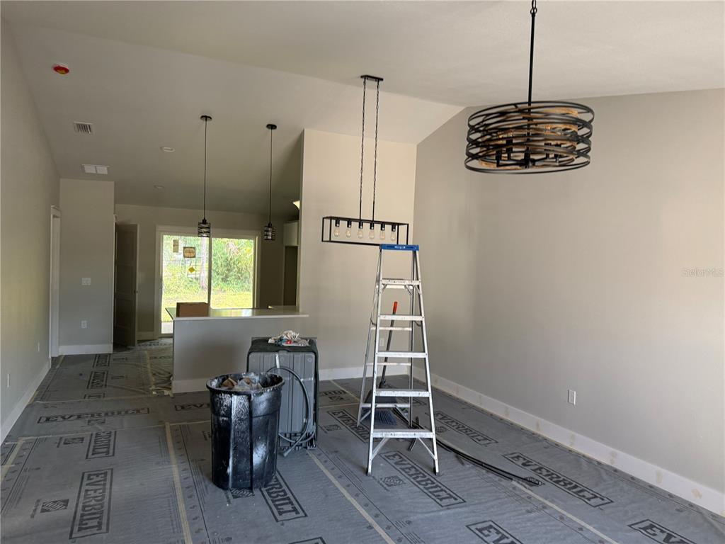 An interior view of a room under construction with a ladder, light fixtures, and floor protection — 62 EMERSON DRIVE, PALM COAST, FL
