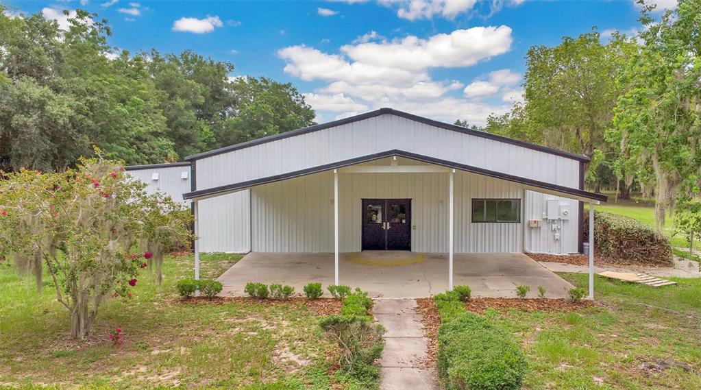 A white metal building with a covered front porch and a concrete walkway — 31336 COUNTY ROAD 437, SORRENTO, FL