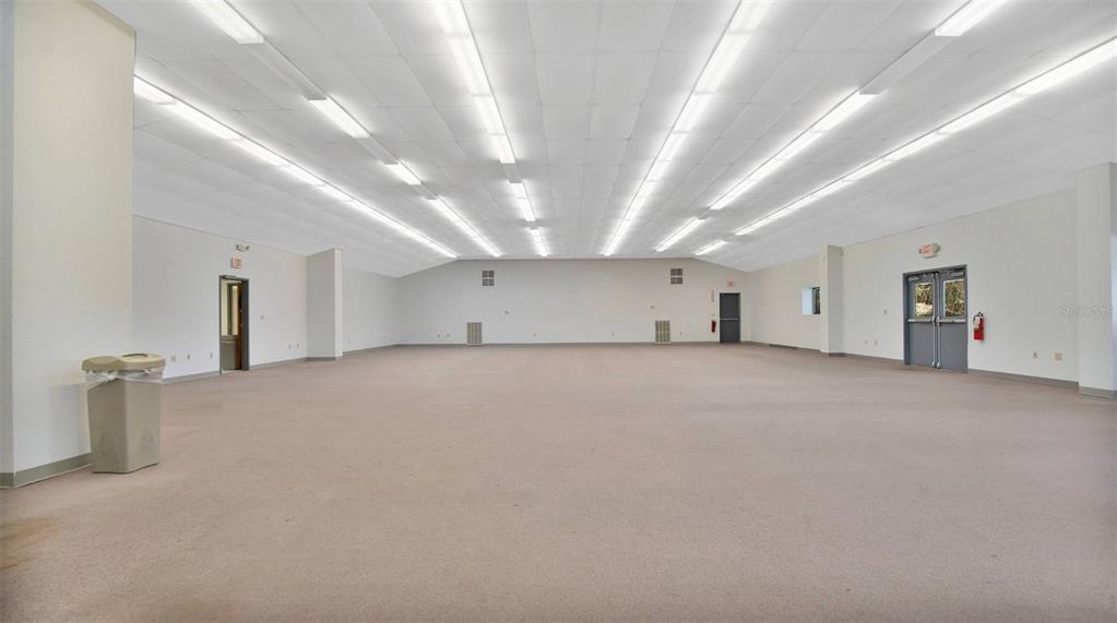 A large, empty commercial room with beige carpeting, white walls, and a drop ceiling — 31336 COUNTY ROAD 437, SORRENTO, FL