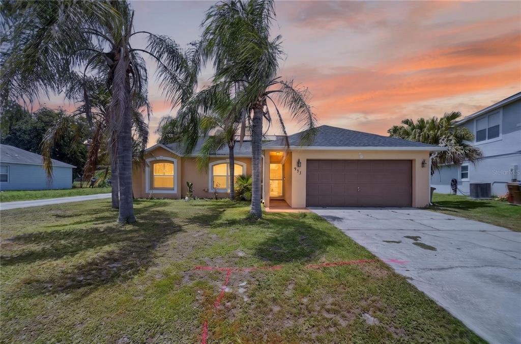 A single-story house with a two-car garage and palm trees in the front yard — 953 GASCONY COURT, KISSIMMEE, FL