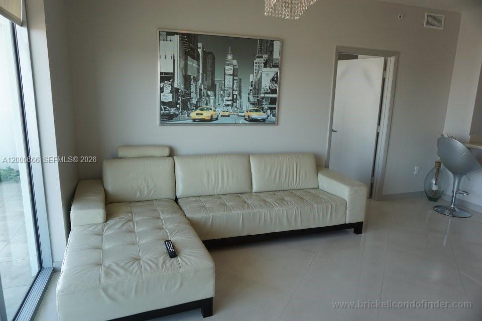 A living room features a white leather sectional sofa and a large black-and-white city print — 90 SW 3rd St # 3505, Miami FL 33130, MIAMI, FL