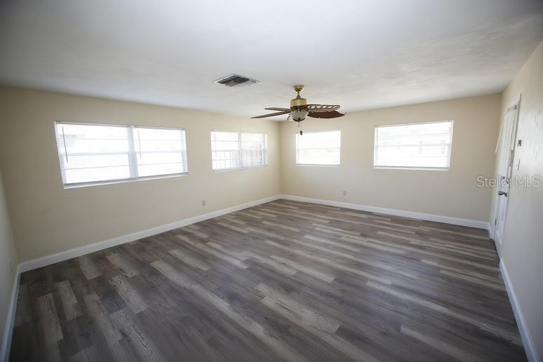 An empty room with light-colored walls, wood-look flooring, and a ceiling fan — 141 W CONNECTICUT AVENUE, EDGEWATER, FL