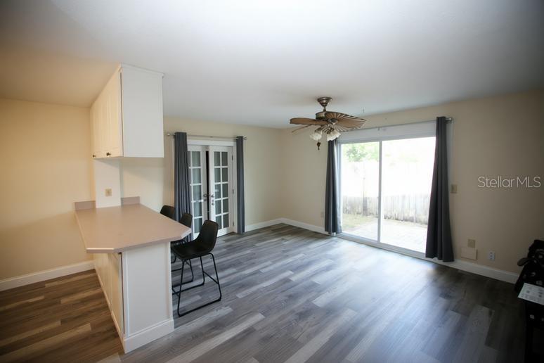 A dining area with a breakfast bar, gray wood-look flooring, and sliding glass patio doors — 141 W CONNECTICUT AVENUE, EDGEWATER, FL