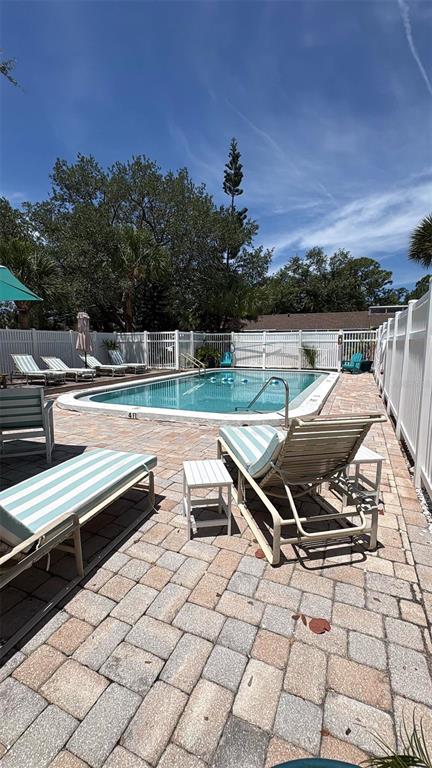 A backyard features a rectangular swimming pool surrounded by a paved patio and lounge chairs — 500 N JEFFERSON AVENUE UNIT G3, SARASOTA, FL