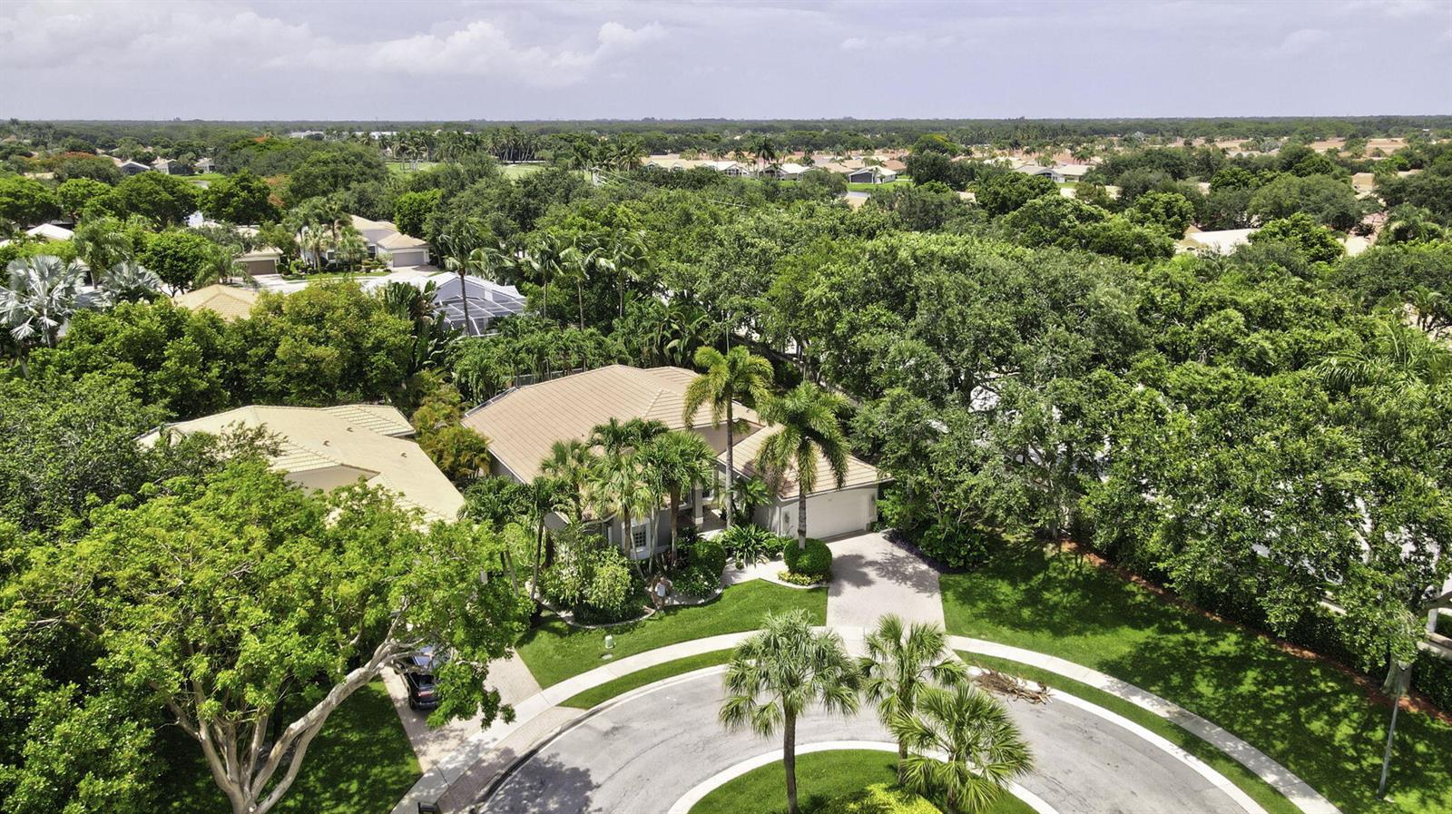 An aerial view of a suburban house with a tan roof surrounded by lush trees — 7527 Monticello Way, Boynton Beach FL 33437, BOYNTON BEACH, FL