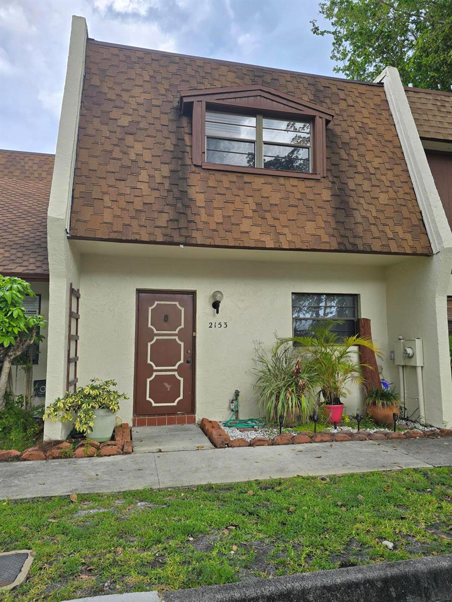 A two-story townhouse exterior features a brown shingled mansard roof and a brown front door — 2153 N 14th Avenue # 2153, Hollywood FL 33020, HOLLYWOOD, FL