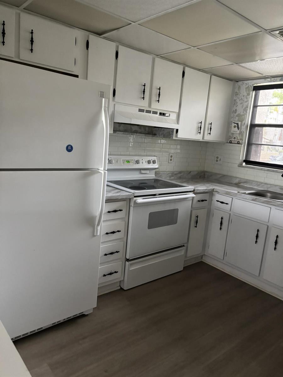 A kitchen features white cabinets, a white refrigerator, a white stove, and a subway tile backsplash — 2153 N 14th Avenue # 2153, Hollywood FL 33020, HOLLYWOOD, FL