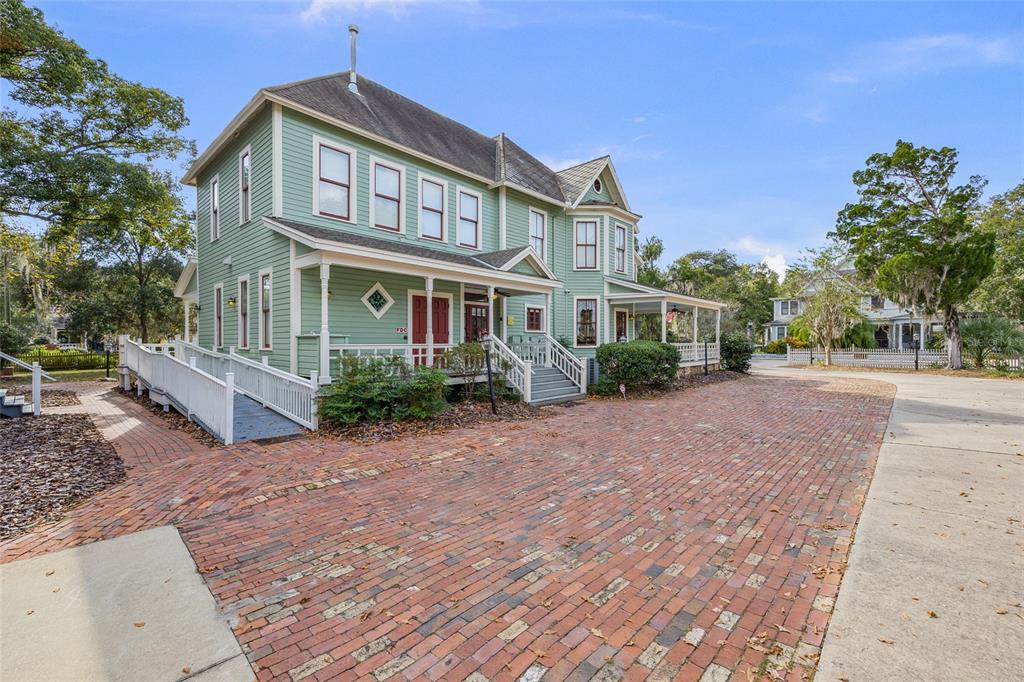 A light green two-story historic house with a brick driveway and a white wheelchair ramp — 205 SE 7TH STREET, GAINESVILLE, FL
