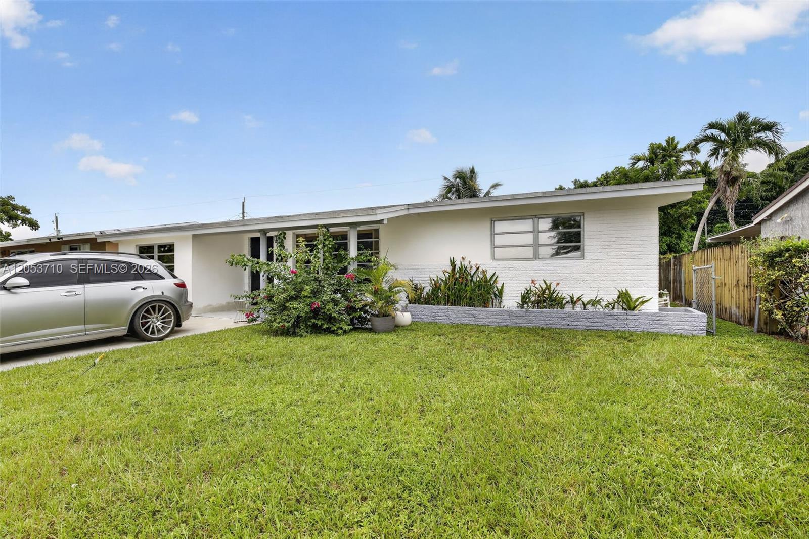 A white, single-story house with a brick facade, a front lawn, and a parked car — 2331 Flamingo Dr, Miramar FL 33023, MIRAMAR, FL