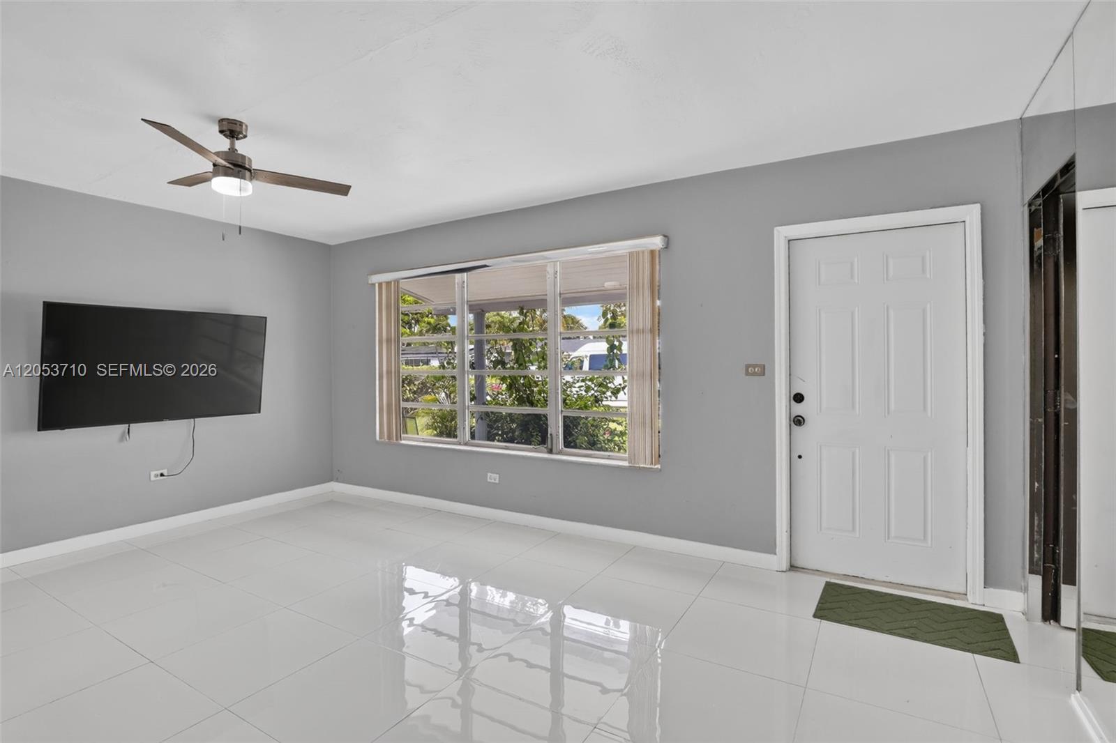 A living room features gray walls, white tile flooring, a ceiling fan, and a front door — 2331 Flamingo Dr, Miramar FL 33023, MIRAMAR, FL