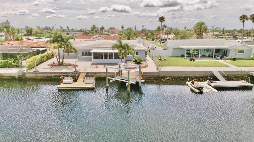 An aerial view shows two waterfront houses with private docks and boat lifts on a canal — 5339 BOWLINE BEND, NEW PORT RICHEY, FL