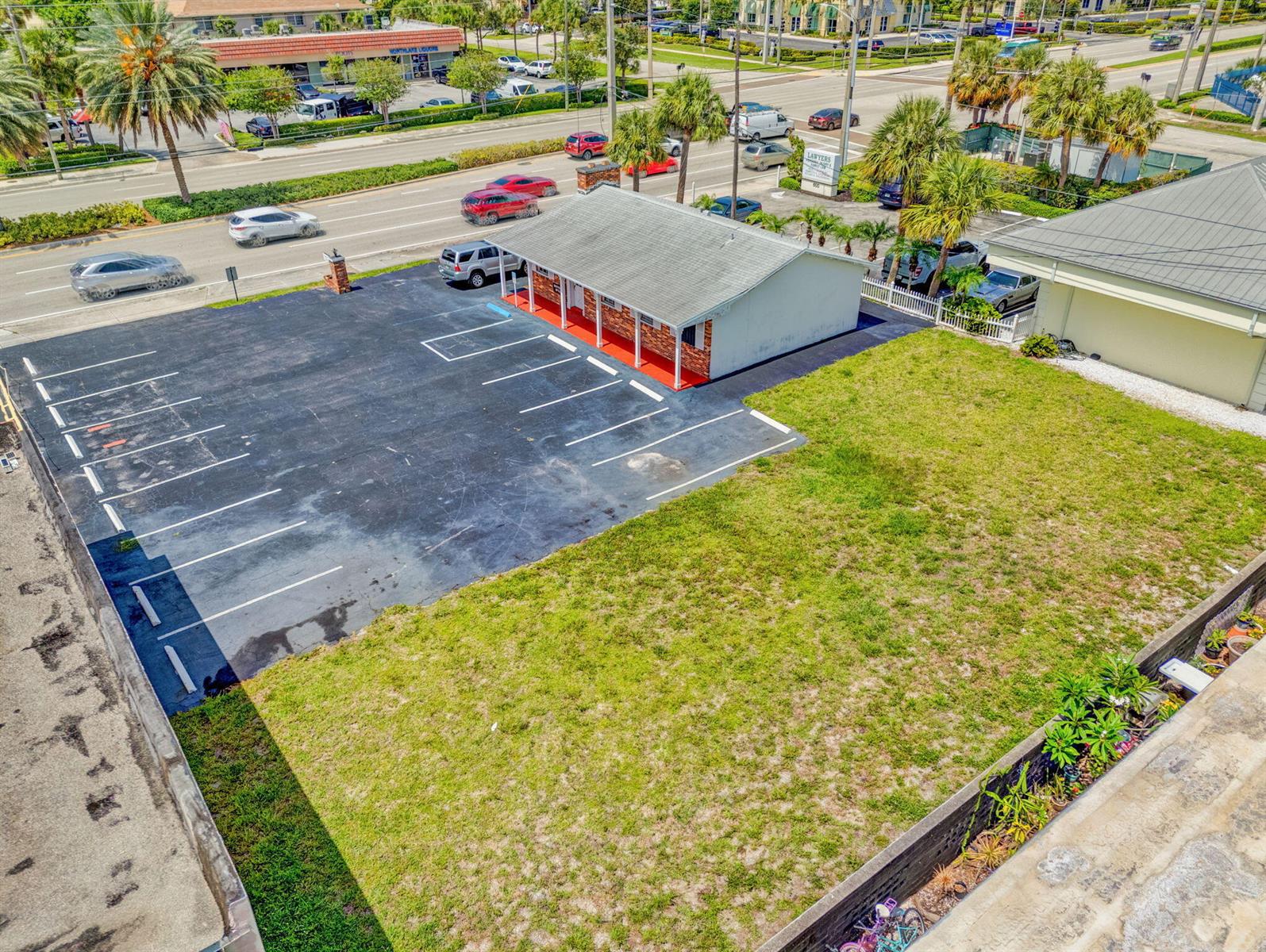 An aerial view shows a commercial building with a parking lot and an adjacent lawn — 610 Northlake Boulevard, Lake Park FL 33408, LAKE PARK, FL