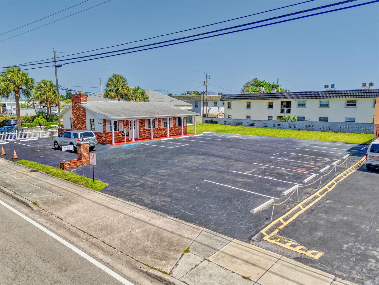 An exterior view of a brick commercial building with a large parking lot — 610 Northlake Boulevard, Lake Park FL 33408, LAKE PARK, FL