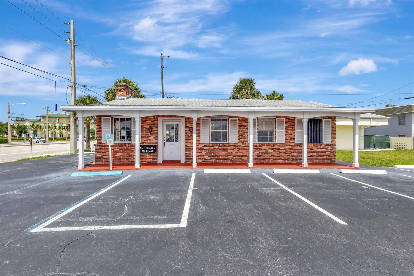 A single-story brick commercial building with a covered porch and parking lot in front — 610 Northlake Boulevard, Lake Park FL 33408, LAKE PARK, FL