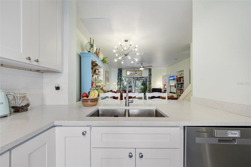 A kitchen sink and countertop overlook a living area with a modern sputnik chandelier — 5937 BAYSIDE KEY DRIVE, TAMPA, FL