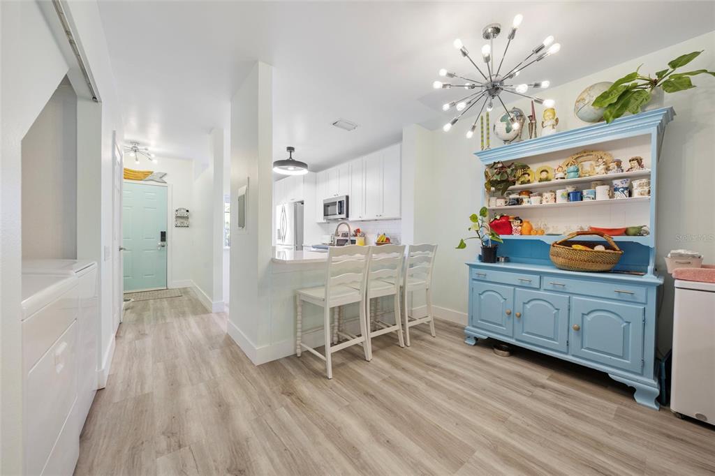 A kitchen and dining area with light wood floors, white cabinets, and a blue hutch — 5937 BAYSIDE KEY DRIVE, TAMPA, FL
