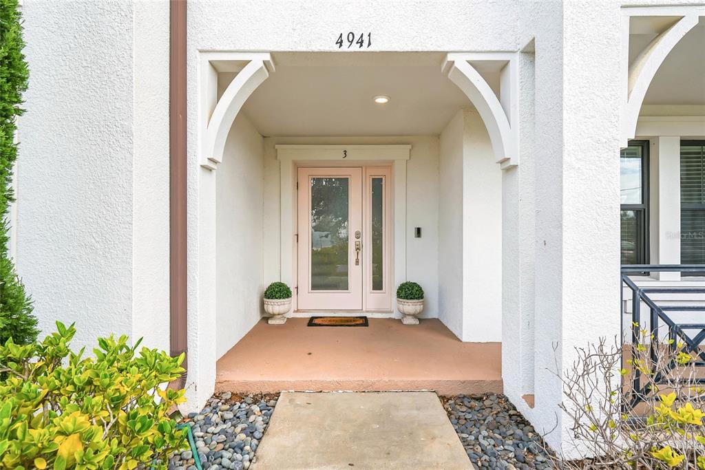 The exterior entrance features a light-colored door with glass panels and two potted plants — 4941 W PRICE AVENUE UNIT 3, TAMPA, FL