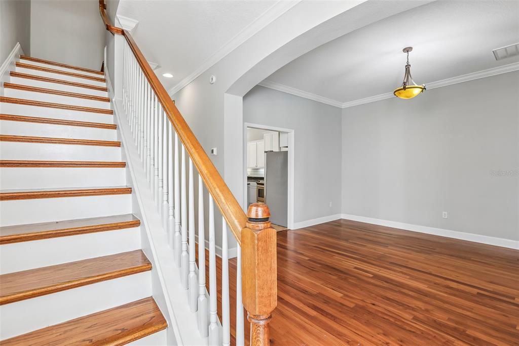 A staircase with wooden treads and white railings leads to an open room with hardwood floors — 502 S LINCOLN AVENUE, TAMPA, FL