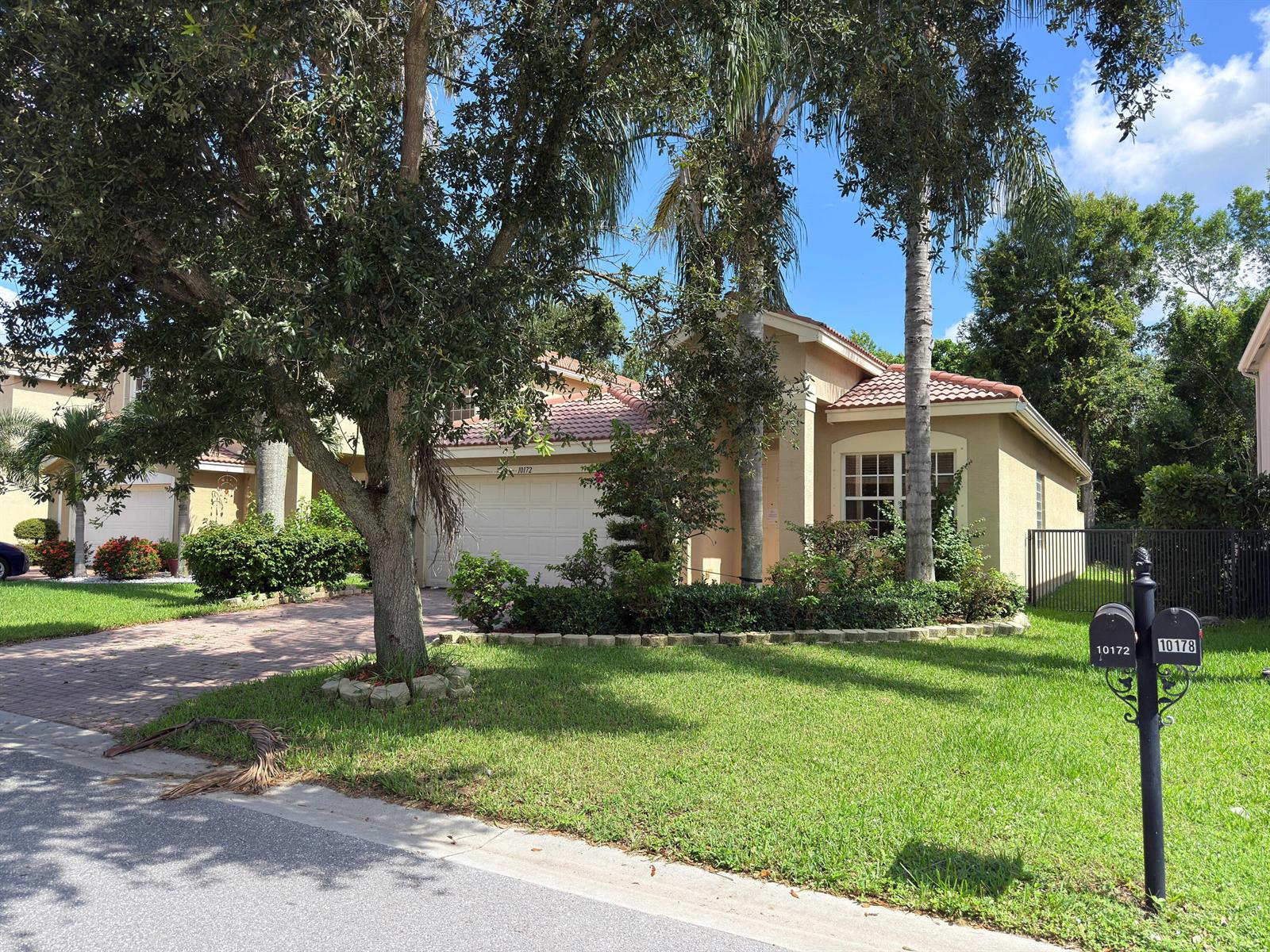 A single-story tan stucco house with a tiled roof and a paved driveway — 10172 White Water Lily Way, Boynton Beach FL 33437, BOYNTON BEACH, FL