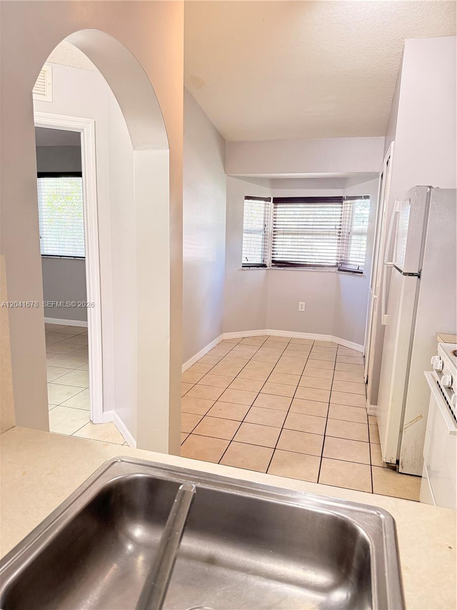 A kitchen with a double sink, tiled floor, and a bay window breakfast area — 2930 SE 12th Rd # 31, Homestead FL 33035, HOMESTEAD, FL