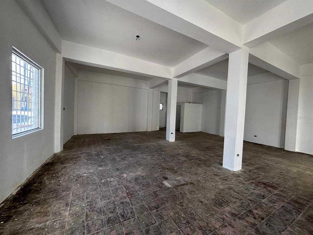 An empty commercial space features white walls, a tiled floor, and exposed structural support columns — 16 CELIS AGUILERA ST. CORNER, MANATI, PR