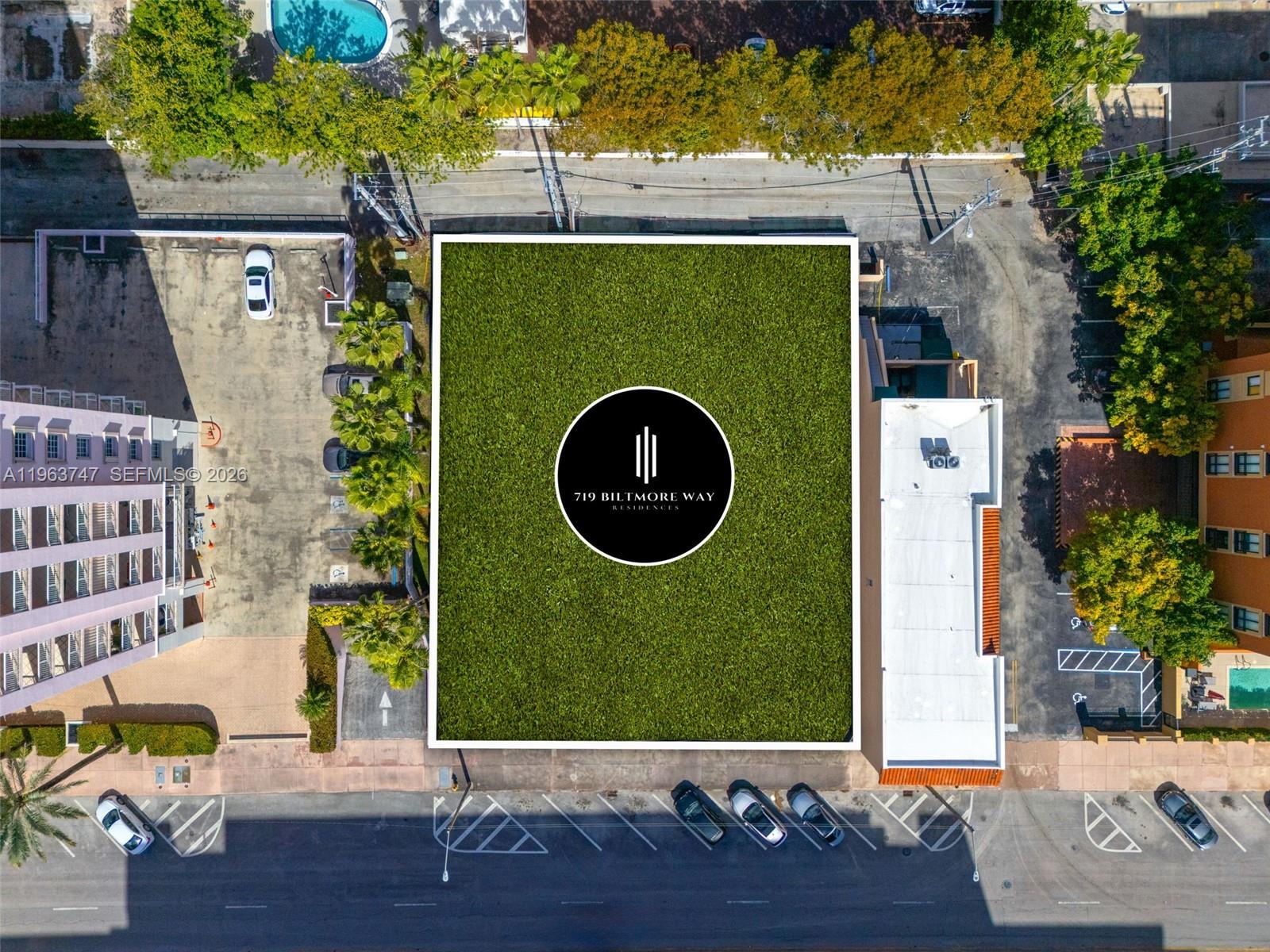 This aerial view shows a vacant rectangular lot with a logo overlay between two buildings — 719 Biltmore Way, Coral Gables FL 33134, CORAL GABLES, FL