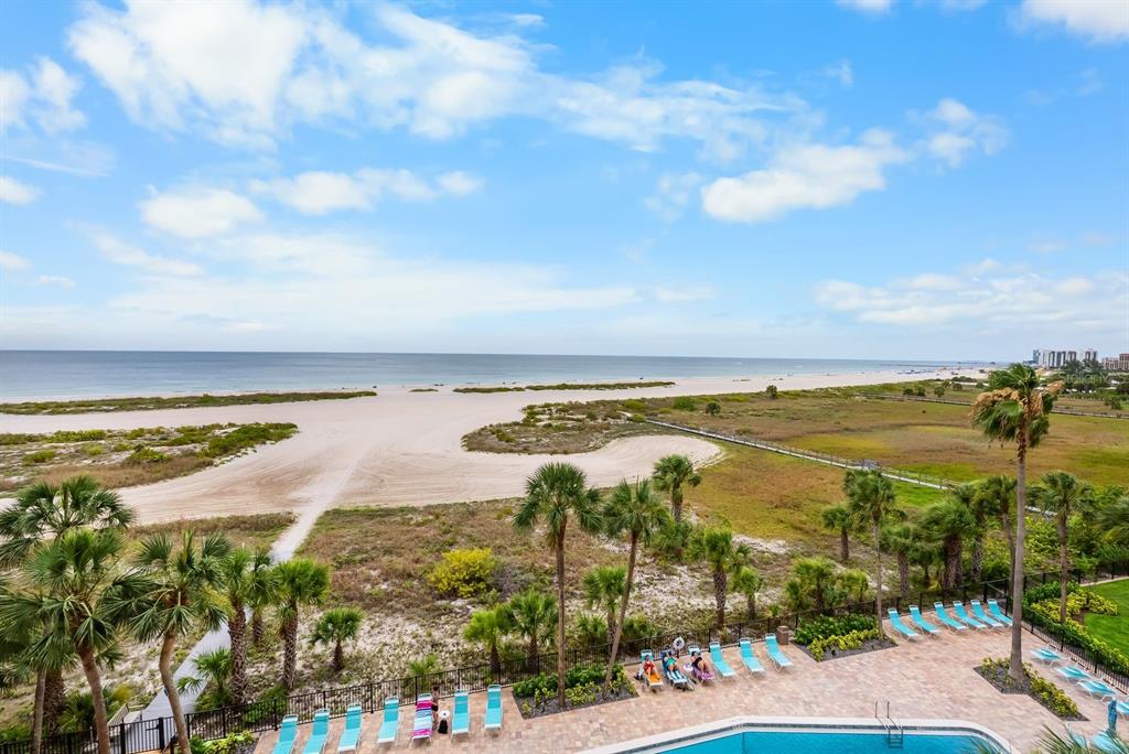 An elevated view of a beach, sand dunes, palm trees, and a swimming pool — 1270 GULF BOULEVARD UNIT 606, CLEARWATER BEACH, FL