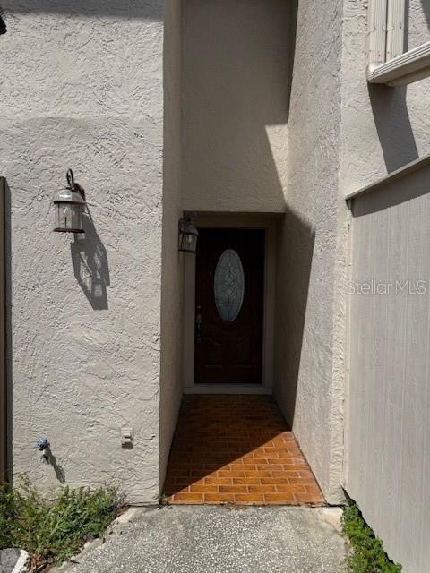A front entryway features a dark wood door with an oval glass insert and brick flooring — 400 S HOWARD AVENUE, LAKELAND, FL