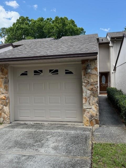 A beige garage door is framed by stone veneer on the exterior of a house — 400 S HOWARD AVENUE, LAKELAND, FL