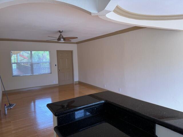 A view of a living area with wood flooring, a ceiling fan, and a kitchen counter — 744 NE 14th Avenue # 12, Fort Lauderdale FL 33304, FORT LAUDERDALE, FL