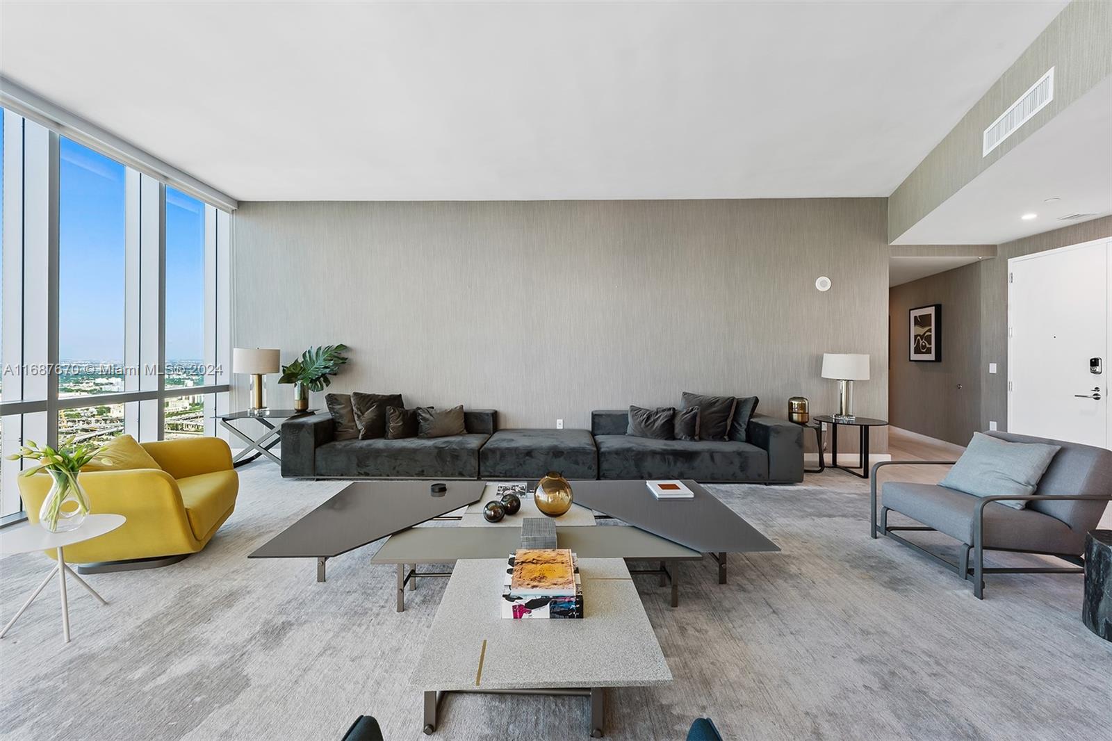 A modern living room features a large grey sofa, a yellow armchair, and a multi-tiered coffee table — 851 NE 1st Ave # 5112, Miami FL 33132, MIAMI, FL