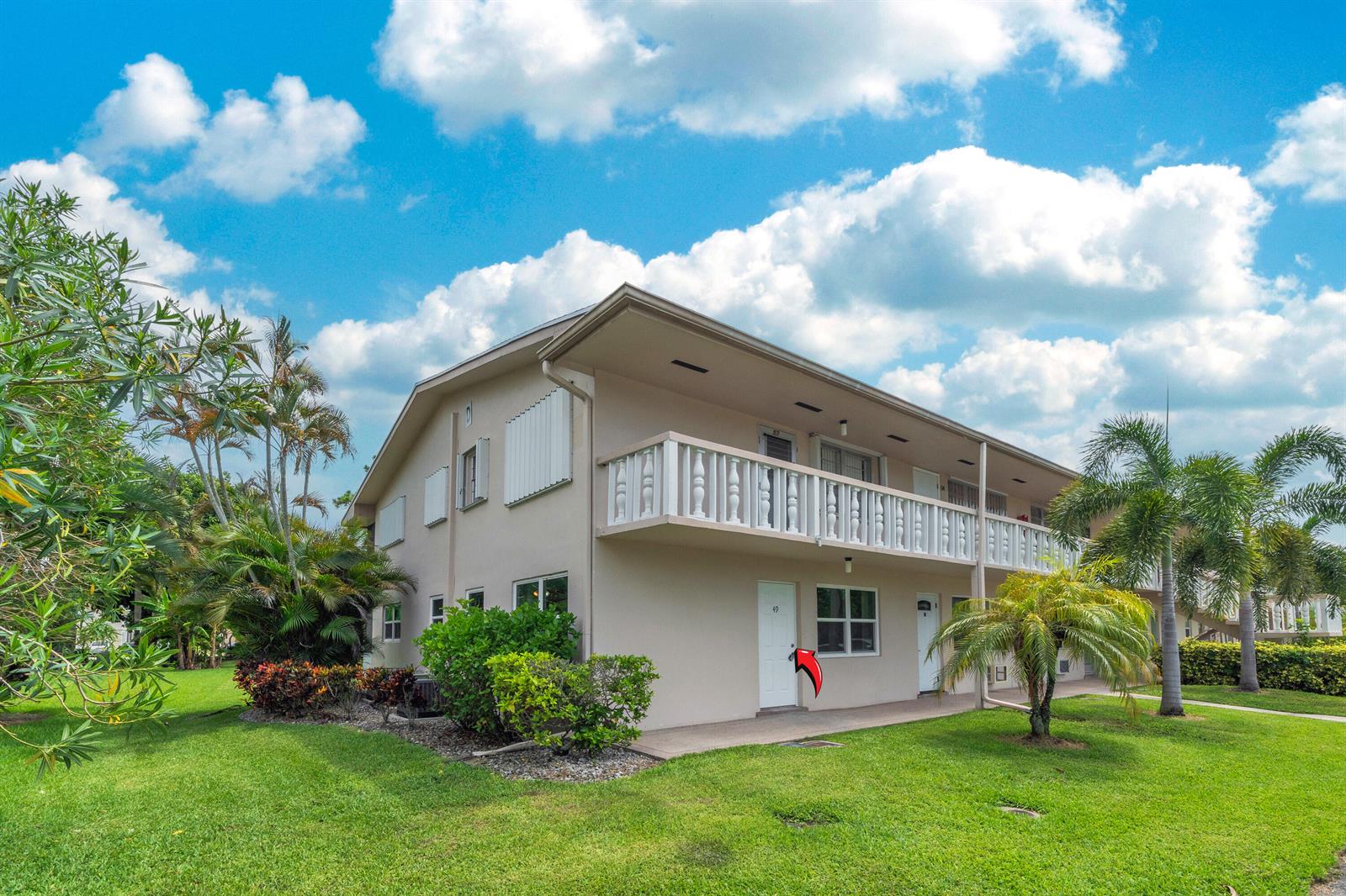 A two-story apartment building with a white balcony and a red arrow pointing to unit 49 — 49 Hastings # D, West Palm Beach FL 33417, WEST PALM BEACH, FL