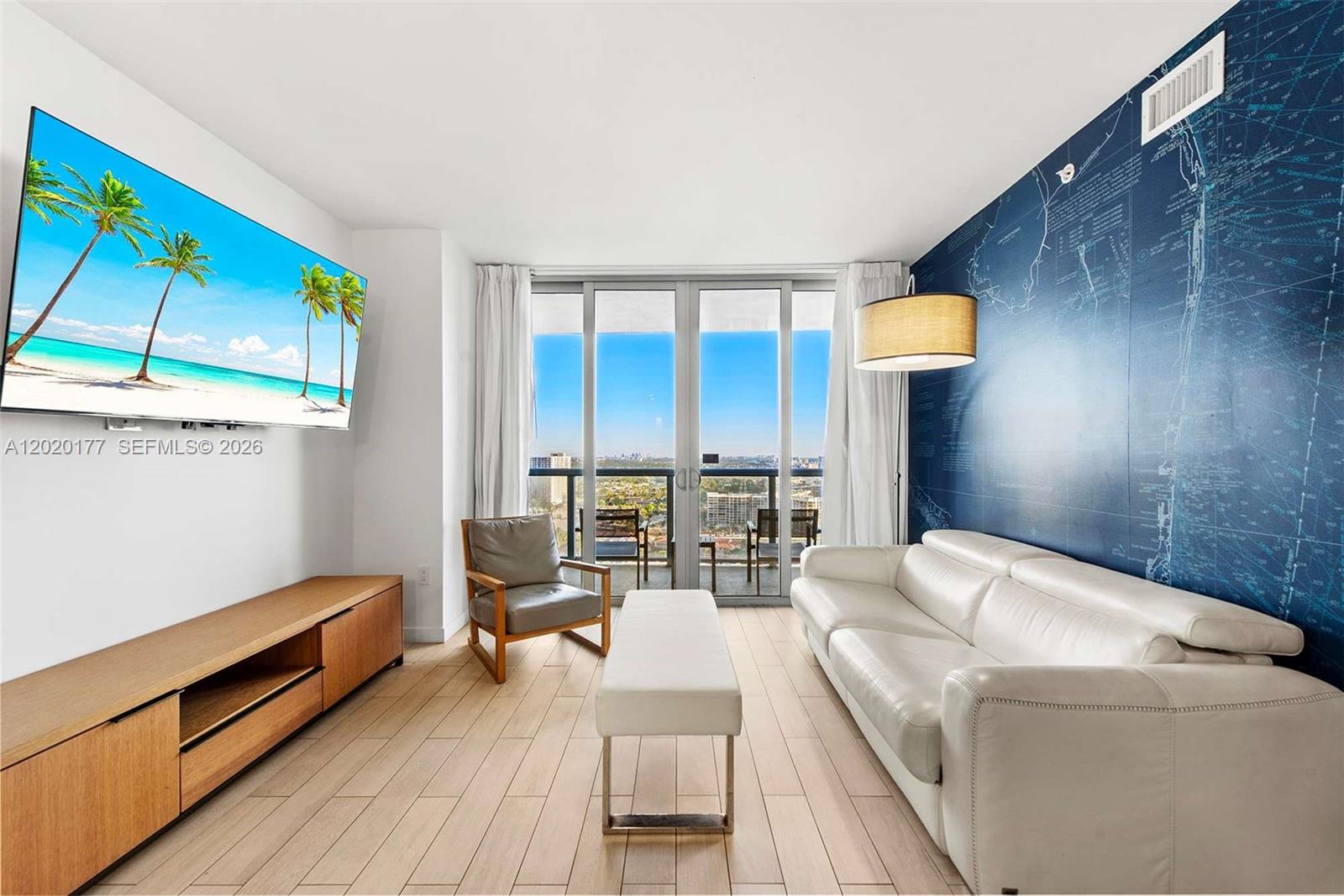 A living room features a white sofa, a wooden media console, and a nautical-themed wall — 2602 E Hallandale Beach Blvd # R2604, Hallandale Beach FL 33009, HALLANDALE BEACH, FL