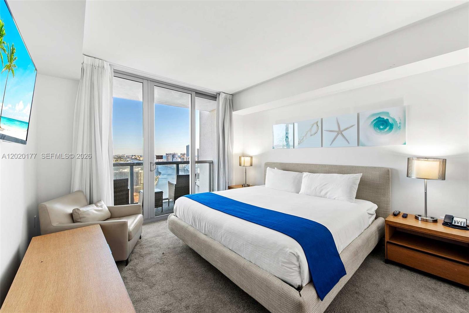 A bedroom features a king bed, a balcony with water views, and a lounge chair — 2602 E Hallandale Beach Blvd # R2604, Hallandale Beach FL 33009, HALLANDALE BEACH, FL