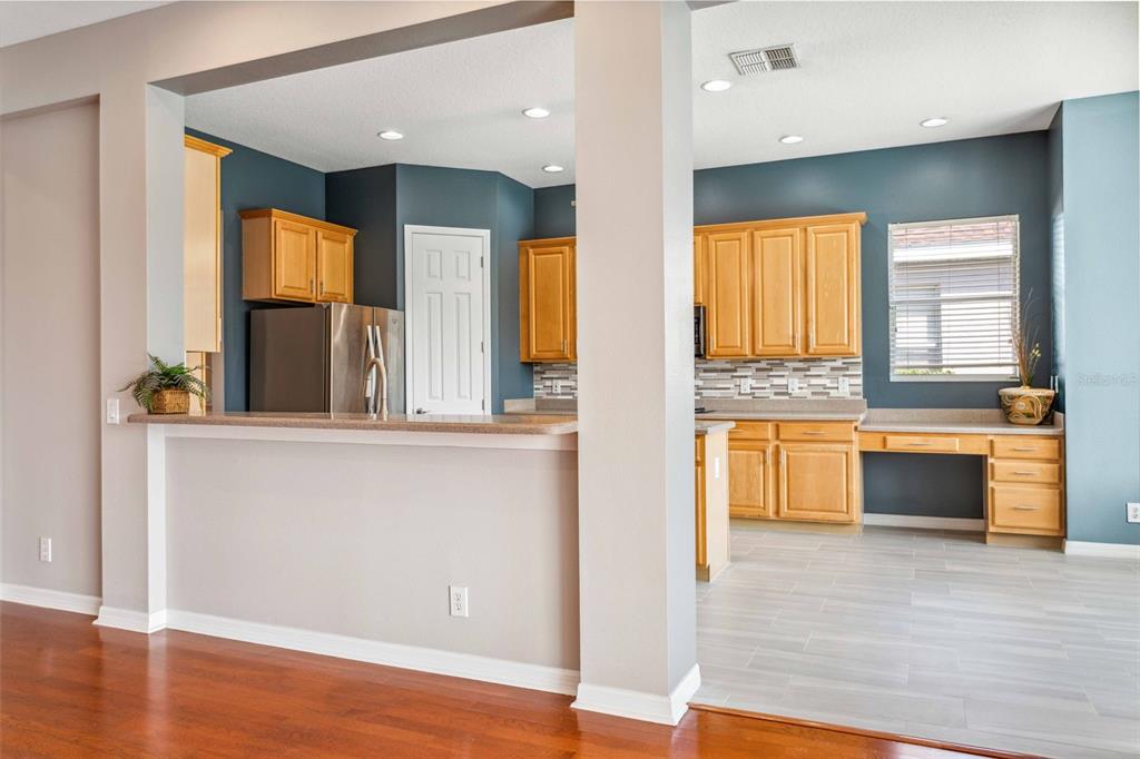 A kitchen with light wood cabinets, dark blue walls, and a breakfast bar counter — 10226 DEERCLIFF DRIVE, TAMPA, FL