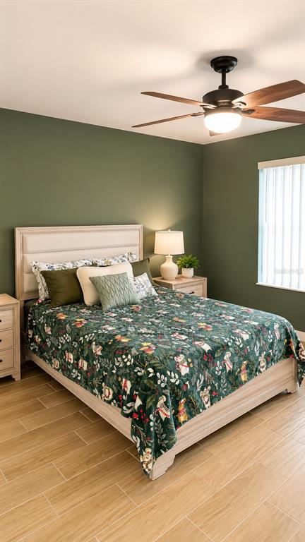 A bedroom features olive green walls, a patterned quilt, and a ceiling fan — 245 WINTER RIDGE BOULEVARD, WINTER HAVEN, FL