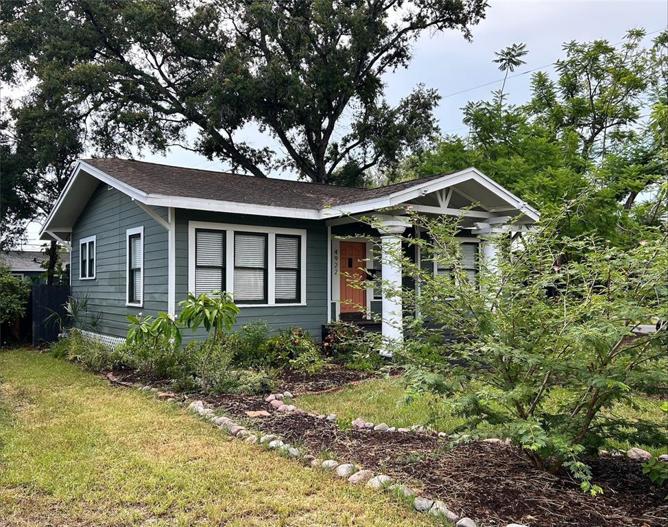 A single-story house with dark green siding, a front porch with columns, and a lawn — 4922 N SUWANEE AVENUE, TAMPA, FL