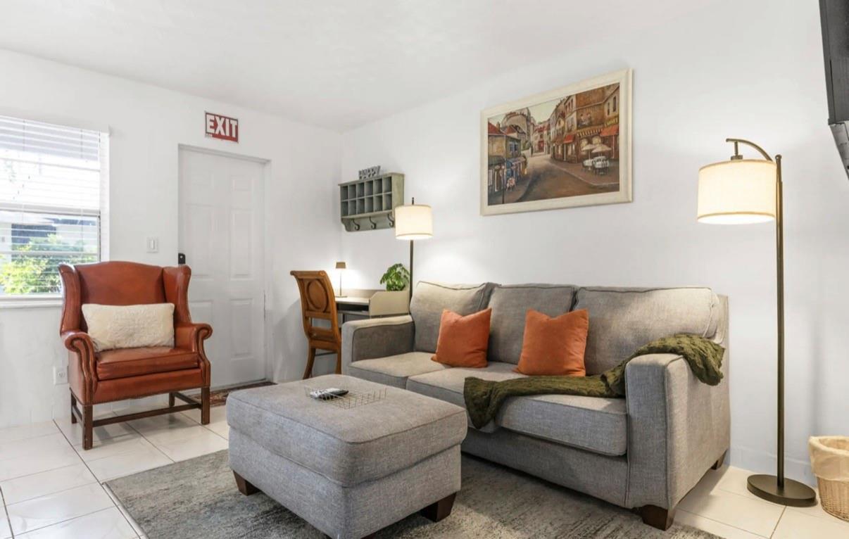A living room features a grey sofa, matching ottoman, leather armchair, and a small desk area — 820 NE 16th Avenue # 3, Fort Lauderdale FL 33304, FORT LAUDERDALE, FL