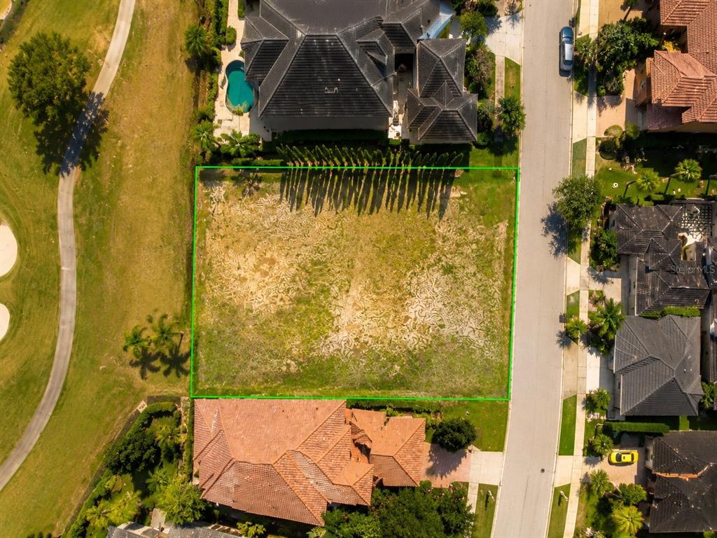 An aerial view shows a vacant rectangular residential lot situated between two houses and a road — 341 MUIRFIELD LOOP, KISSIMMEE, FL