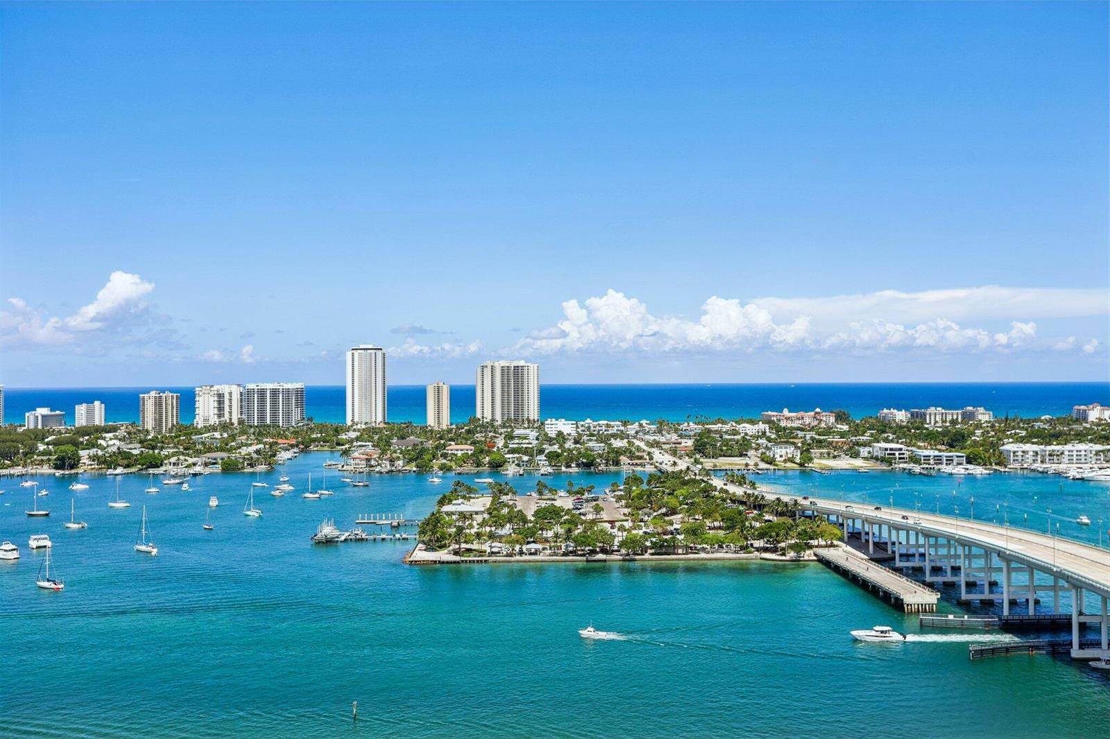 An aerial view of a coastal city with a bridge, boats, and high-rise buildings — 2640 Lake Shore Drive # 2508, Riviera Beach FL 33404, RIVIERA BEACH, FL