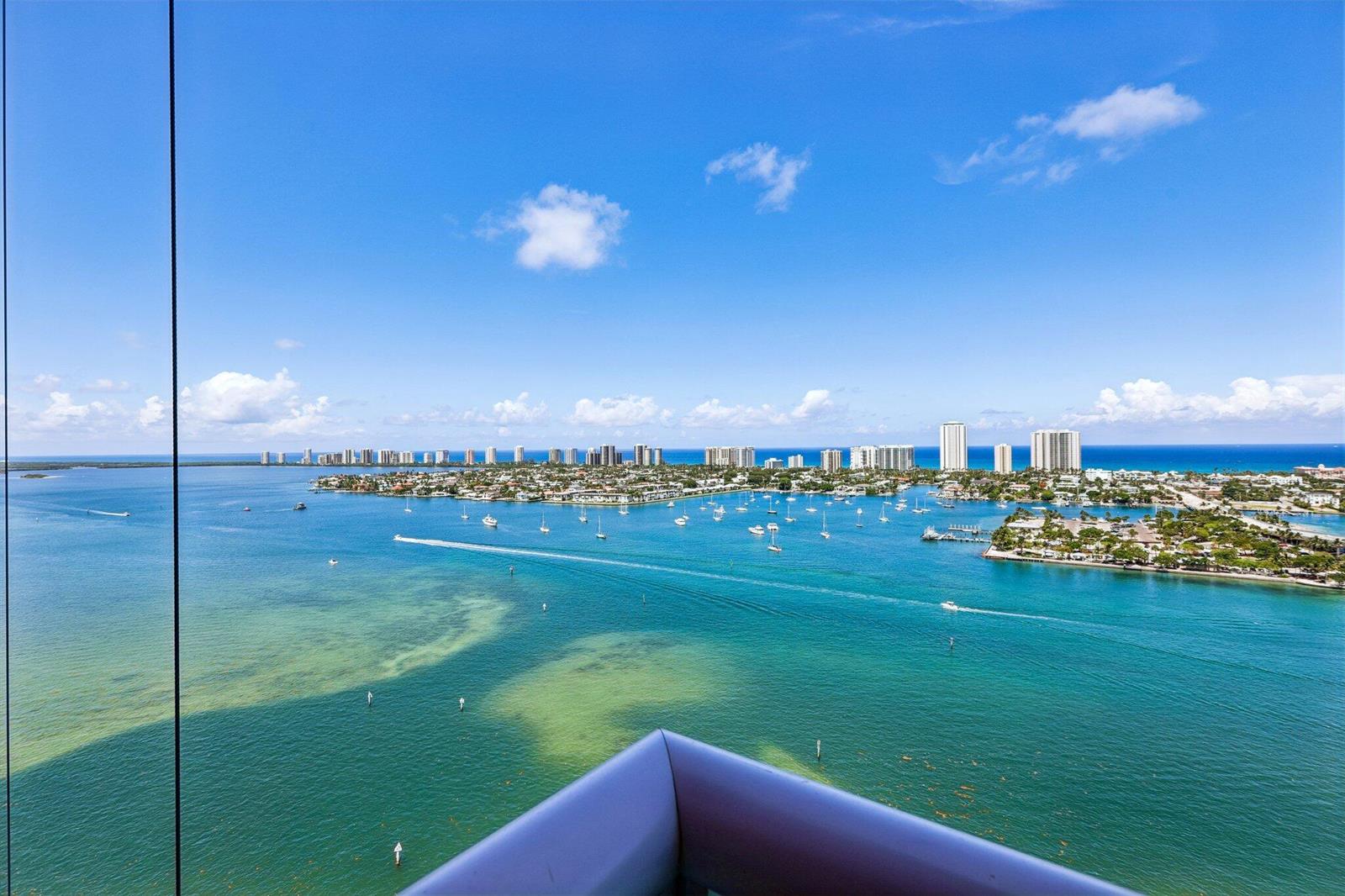 A high-angle view of a bay with boats, coastal buildings, and a clear blue sky — 2640 Lake Shore Drive # 2508, Riviera Beach FL 33404, RIVIERA BEACH, FL