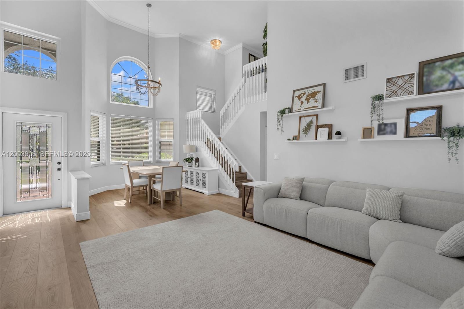 A bright living room features a high ceiling, a staircase, and a dining area — 1651 NW 104th Ave, Plantation FL 33322, PLANTATION, FL
