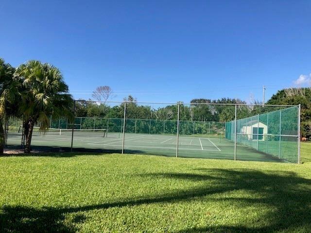 A fenced tennis court sits next to a grassy lawn and a small storage shed — 6303 SE Williamsburg Drive # 201, Hobe Sound FL 33455, HOBE SOUND, FL